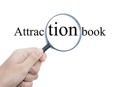 Hand Showing Attraction book Word Through Magnifying Glass の写真素材