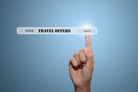 Business and technology, searching system and internet concept - male hand pressing Search TRAVEL OFFERS button.の写真素材
