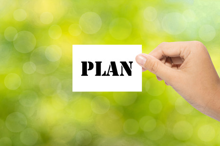Hand holding a paper plan on green backgroundの写真素材