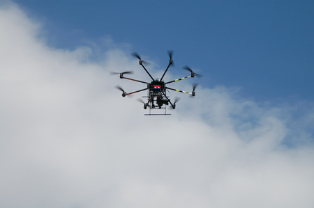 Aircraft type Dron photographed from the ground in flight and shooting events below it.のeditorial素材