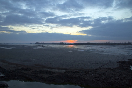 Sunset on the pond that is discharged due to the arrival of winter. The fish are overfished and in winter quarters.の写真素材