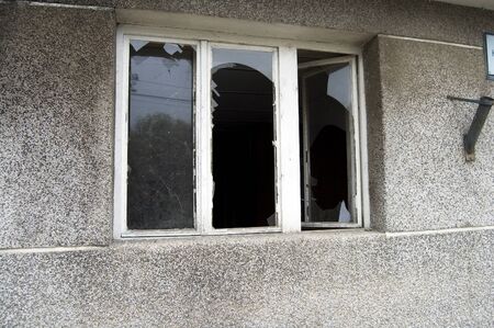 The old wooden three-bladed window with broken glass.の写真素材
