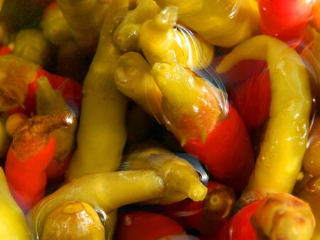 Vew of an open jar of homemade chili peppers in a solution of vinegar, water and salt.の写真素材