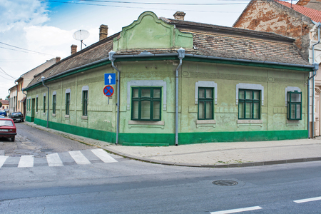 Old beautiful, low town house on the corner of two streets with a satellite dish on the roof.の写真素材