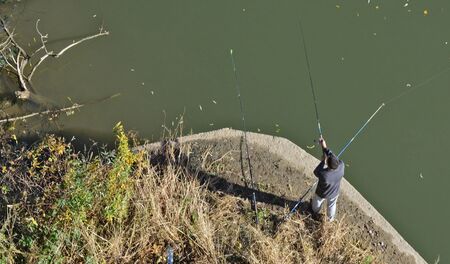 Fisherman at the foot of the bridge catching fish.の写真素材
