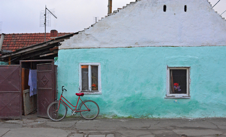 Red bicycle leaning against the wall of the old house.の写真素材
