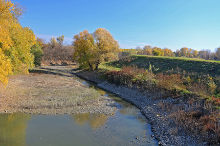 Stream flows through the autumn landscape.の写真素材