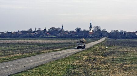 Tractor with two trailers transporting hay.の写真素材