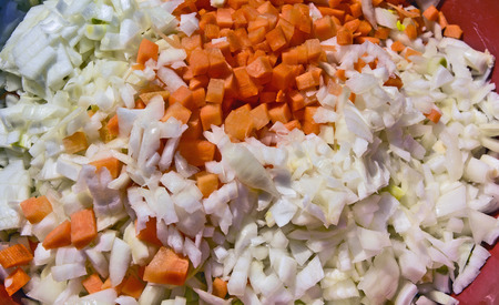 Finely sliced carrots and onions in a bowl ready for cooking goulash.の写真素材