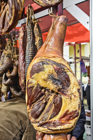 Dried and smoked ham and other products on the open booth of the traditional fair.の写真素材