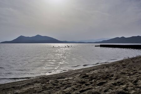 A group of swimmers in Greece bathe in the sea before sunset.