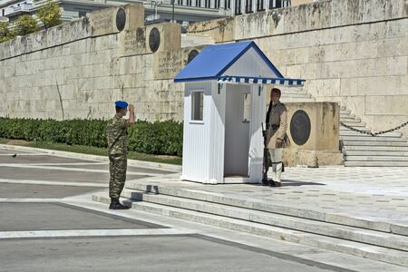 ATHENS, GREECE - JUNE 04, 2016 Evzonese (presidential guards) are watching over a monument to an Unknown Soldier in front of a Greek Parliament building in Syntagma Square. Arrival of the officer who organizes and monitors the shift of the guard.のeditorial素材