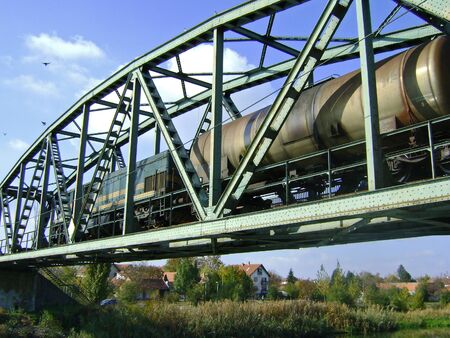 Zrenjanin, Serbia, October 28, 2009. A diesel locomotive pulling a train enters a bridge across the river.のeditorial素材