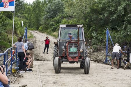 Taras, Tisa River, Serbia, Jun 10, 2017. An old traditional ferryboat sails and connects the two shores. The scaffold is used mostly by farmers who have estates on both sides of the river.のeditorial素材
