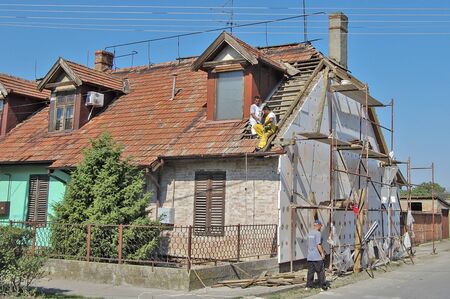 Zrenjanin, Serbia, July 17, 2013. A group of workers is working on the reconstruction of the attic of an apartment building.のeditorial素材