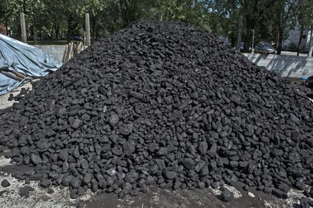 A pile of brown coal in a warehouse waiting for customers for the winter.