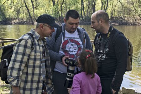 Ivanovo, Serbia, April 09, 2017. A group of photographers and a girl by the river share their experiences.のeditorial素材