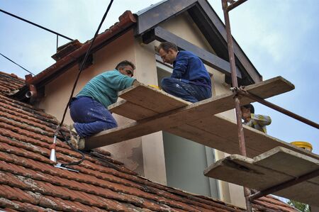 Zrenjanin, Serbia, September 29, 2013. A group of workers is working on the reconstruction of the attic of an apartment building.のeditorial素材