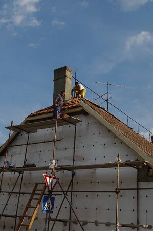 Zrenjanin, Serbia, July 04, 2013 A group of workers is working on the attic of a residential building. They perform thermal insulation and repair of the roof structure.のeditorial素材