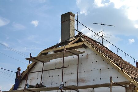 Zrenjanin, Serbia, July 04, 2013 A group of workers is working on the attic of a residential building. They perform thermal insulation and repair of the roof structure.のeditorial素材