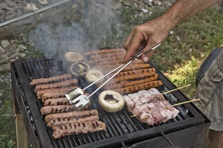 Preparing barbecue meat at picnic in nature. The meat is roasted in a conventional way.