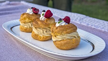 Three princess donuts on a plate with sweet fruit decorations on them.の写真素材