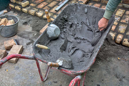 Parked trolley, mortar and tools to help build the building. Several of the masons present use...