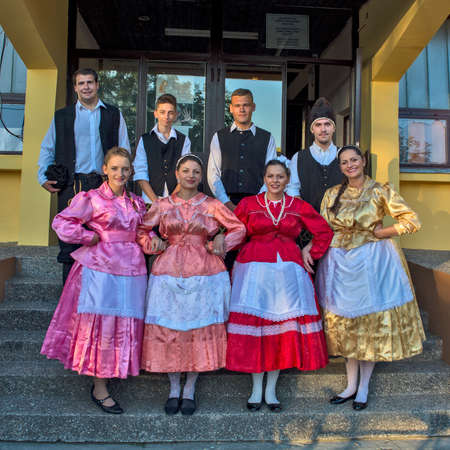 Ivanovo, Serbia, August 15, 2016. A group of young men and women who are participants in folklore events pose in front of the House of Culture. They are wearing Bulgarian national costumes.のeditorial素材
