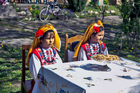 Ivanovo, Serbia, April 09, 2017. Two girls, sisters sitting at a table and posing for photographers. A gathering of photo amateurs is organized in Ivanovo every April.のeditorial素材
