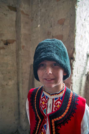 Ivanovo, Serbia, April 09, 2017. A boy with freckles on his face in a Bulgarian national costume and a hat posing for photographers. A gathering of photo amateurs is organized in Ivanovo every April.のeditorial素材