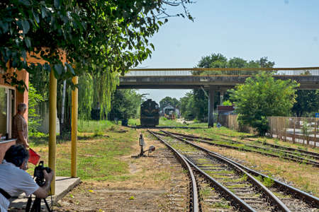 Zrenjanin,Serbia,August 31,2020.Diesel locomotives 661-243 of Serbian railways leave the station and pass under the overpass.Photographer and a railroad officer are waiting for the locomotive to pass.のeditorial素材