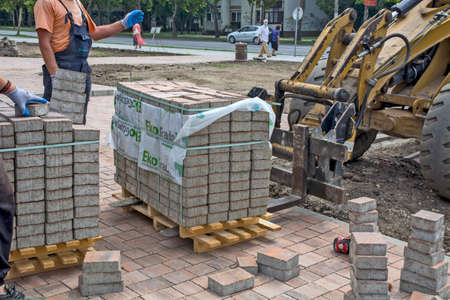 Zrenjanin, Serbia, August 14, 2020. Works on the installation of a decorative sidewalk in the city. Delivery of materials on pallets by motor vehicle.のeditorial素材