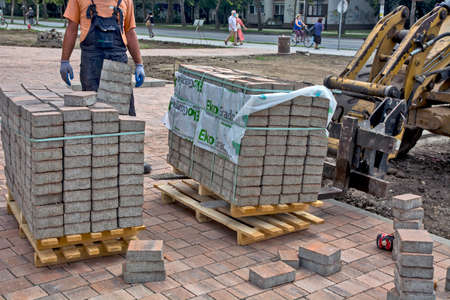 Zrenjanin, Serbia, August 14, 2020. Works on the installation of a decorative sidewalk in the city. Delivery of materials on pallets by motor vehicle.のeditorial素材