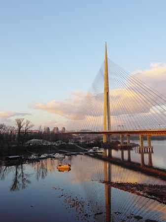 Cable bridge and boats underneath at sunsetの写真素材