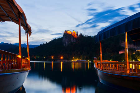 Silent evening, boats on the calm lake and the old castle above the lake のeditorial素材