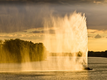 Dark clouds and strong wind create water curtain against sunset lightの写真素材