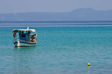 Small fishing boat and a big seagull in Greeceの写真素材