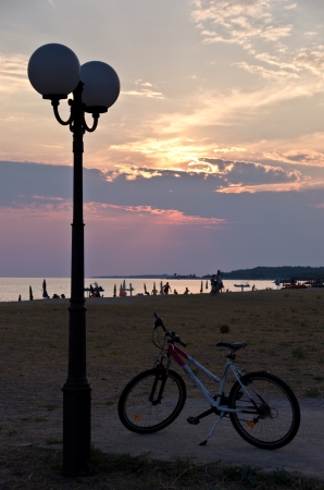 Lantern and bicycle by the beach at sunset, Sithonia, Greeceの写真素材