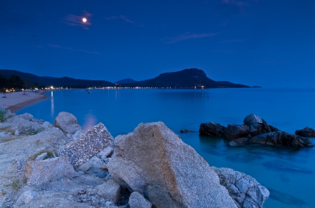 Rocks and sandy beach under the moon shine after twilight, Sithonia, Greeceの写真素材