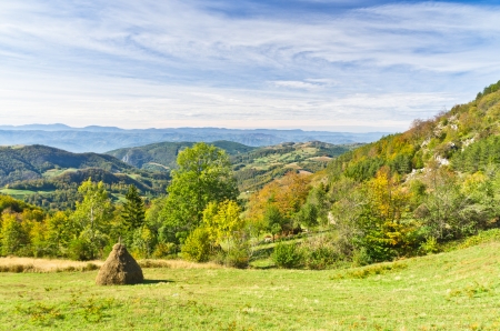 Viewpoint on a landscape of mount Bobija, hills, haystacks, meadows and colorful trees, west Serbiaの写真素材