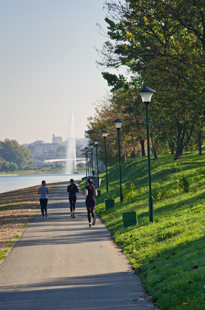Girls jogging on a path by the lake at sunny morning, Belgrade, Serbiaのeditorial素材