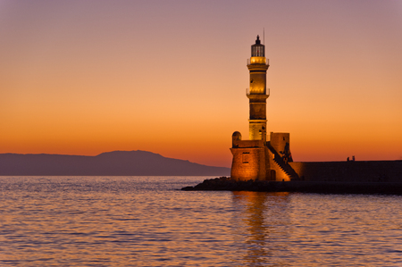 Scenic view of the entrance to Chania harbor with lighthouse at sunset, Crete, Greeceの写真素材