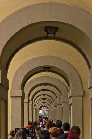 River of tourists flow towards Ponte Vecchio bridge in Florence, Italyの写真素材