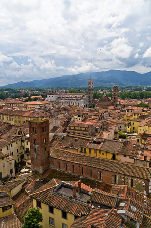 Cityscape of Lucca with cathedral and surrounding mountains, Tuscany, Italyの写真素材