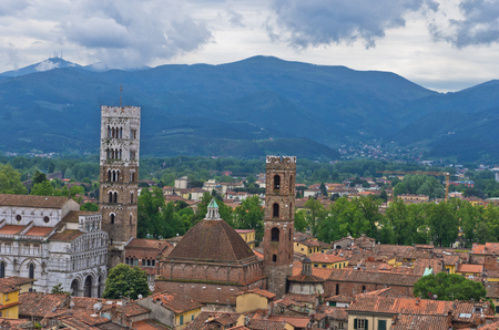 Cityscape of Lucca with cathedral and surrounding mountains, Tuscany, Italyの写真素材