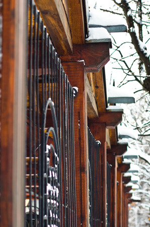 Detail of a wooden and black metal fence covered with snow during winter at Kosutnjak park, Belgrade, Serbiaの写真素材