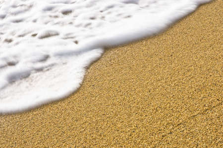 Wave motion blur and sharp sand on a beach at small greek village Toroni in Sithonia, Greeceの写真素材
