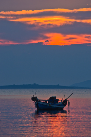 Silhouette of a fishing boat at sunset, Sithonia, Greeceの写真素材