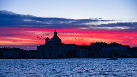 Red sky at sunrise in Venice near Grand Canal, San Giorgio Maggiore church in background, Italyの写真素材