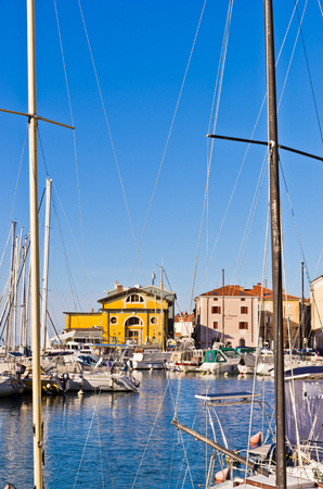 White boats, blue sky and colorful buildings at Piran harbor, Istria, Sloveniaのeditorial素材